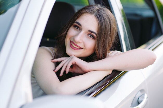 A young girl is driving a car.