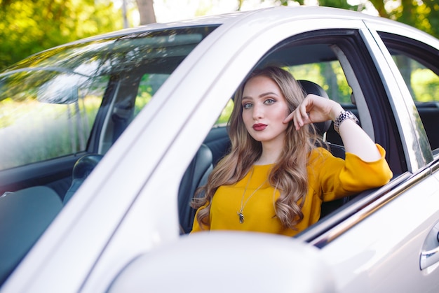 A young girl is driving a car.