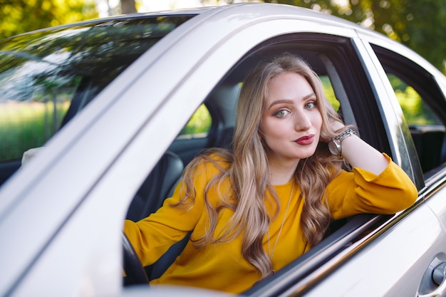 A young girl is driving a car.