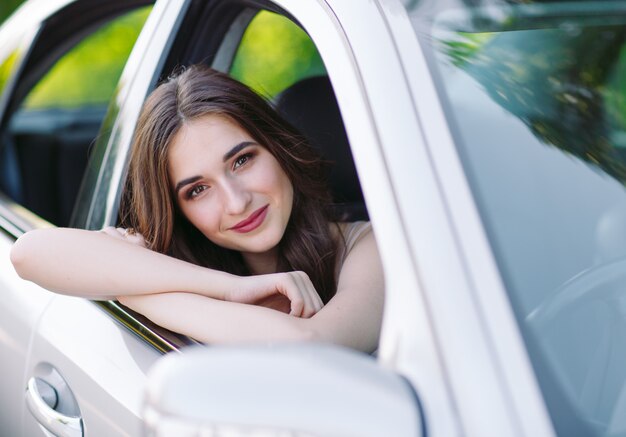 A young girl is driving a car.