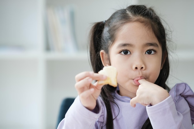 한 어린 소녀 가 과일 한 조각 을 먹고 있다