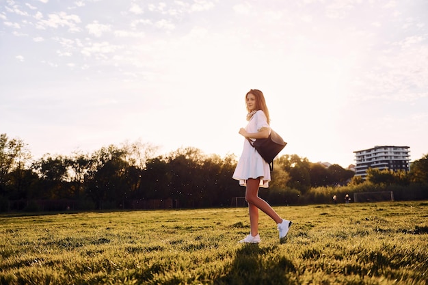 Photo young girl is on the field at sunny daytime having nice weekend