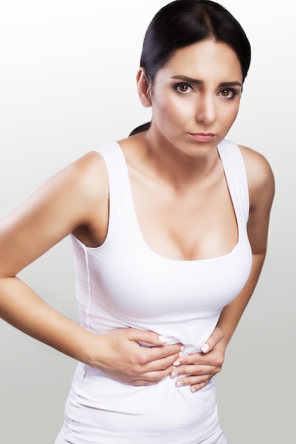 A young girl is holding hands below her stomach