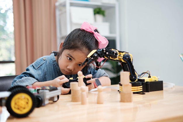 A young girl is playing with a remote control a robot