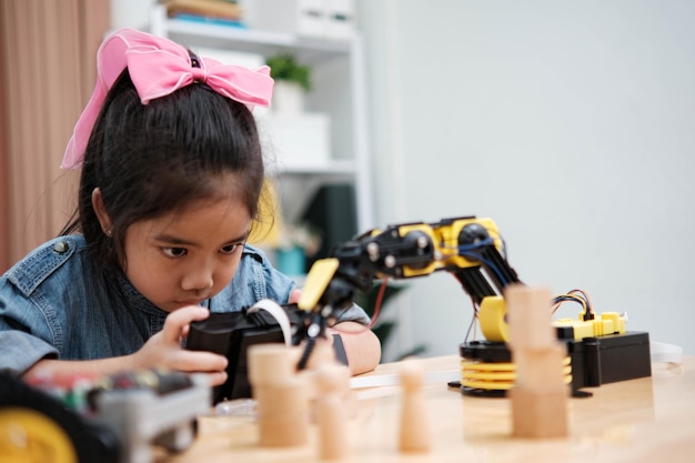 A young girl is playing with a remote control a robot