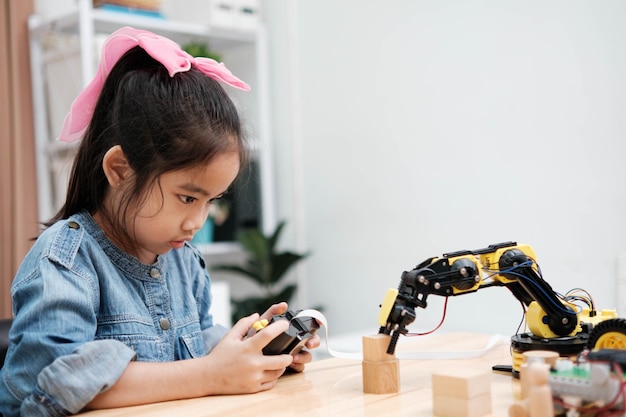 若い女の子がロボットのリモコンで遊んでいます