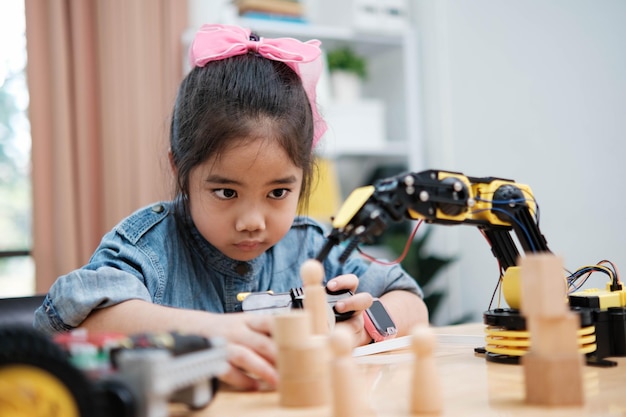 A young girl is playing with a remote control a robot