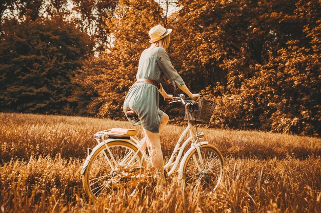 若い女の子がレトロな自転車を背景に本を読んでいます。