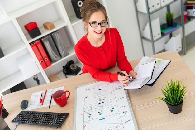 A young girl is sitting at the desk in the office