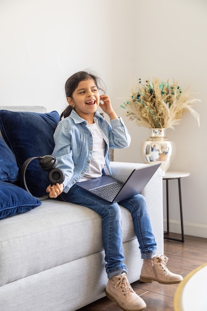 Young girl is using her laptop on the living room