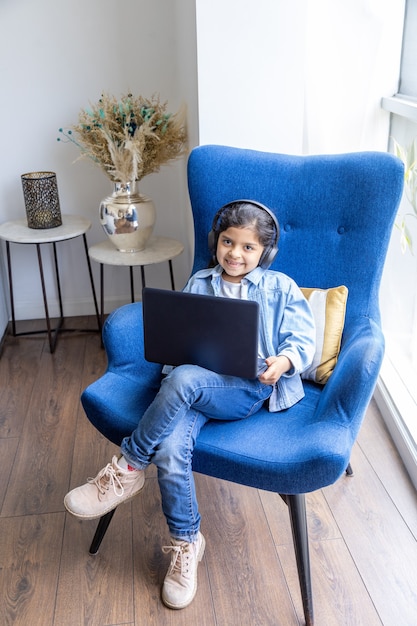 Young girl is using her laptop on the living room