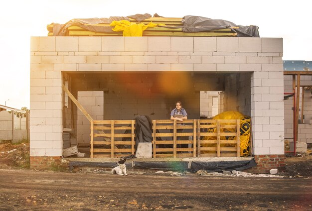 A young girl is waiting for the completion of the construction of a country house, concept of the building home for living