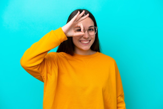 Young girl isolated on blue background With glasses with happy expression