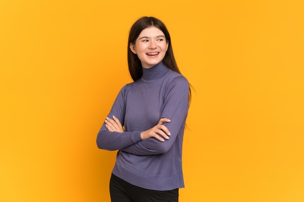 Young girl isolated on yellow happy and smiling