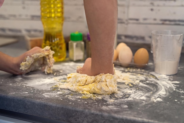 Young girl in the kitchen breaks eggs and sprinkles flour to bake a cool birthday cake