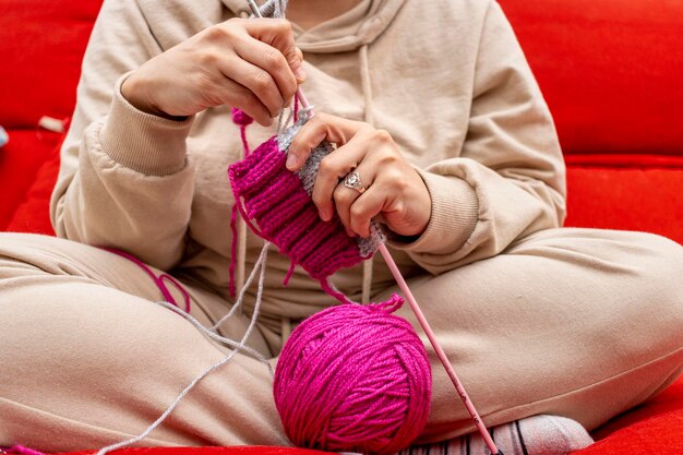 Young girl knitting with natural wool balls