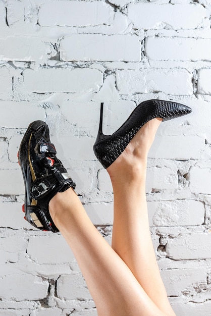 Young girl legs in heels and cycling shoes on white background