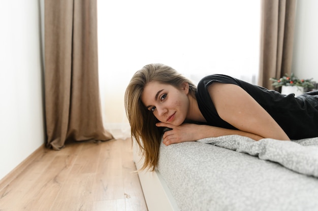 Young girl lies on the bed.