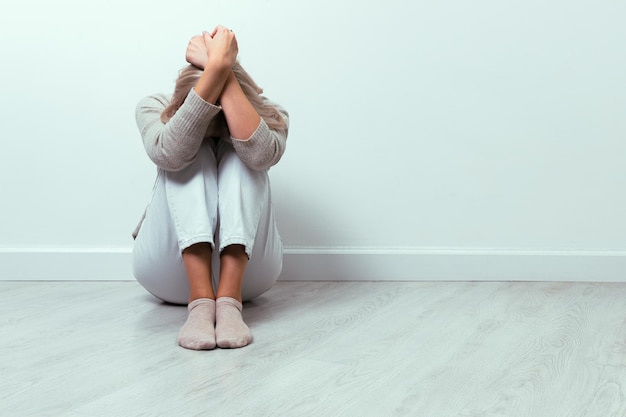 A young girl lies curled up on the floor. Depression concept.