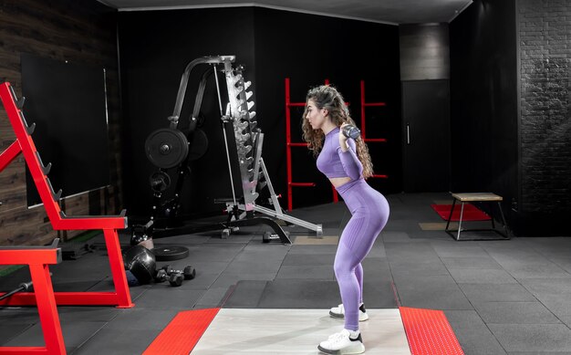 Young girl lifting weights in the gym.