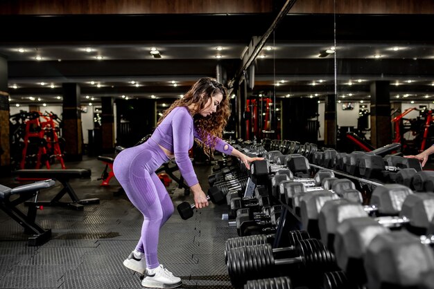 Young girl lifting weights in the gym.