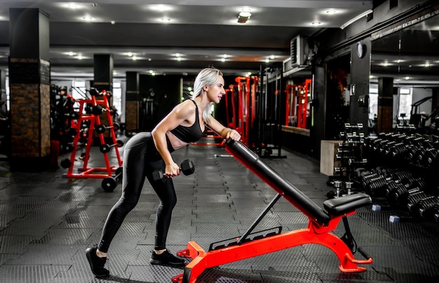 Young girl lifting weights in the gym.