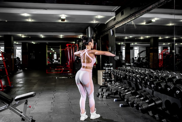 Young girl lifting weights in the gym.