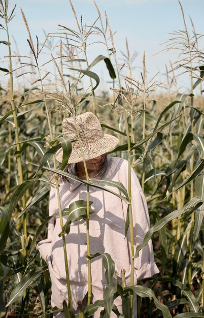 夏の晴れた日にリネンのスーツと帽子をかぶった少女は、旅行が大好きなトウモロコシ畑に立っています。