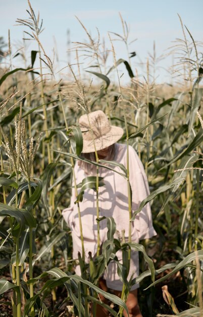 Young girl in a linen suit and a hat on a summer sunny day stands in a corn field love of travel and