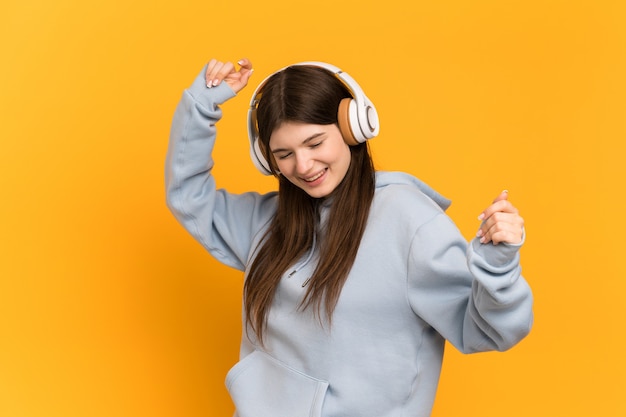 Young girl listening music and dancing