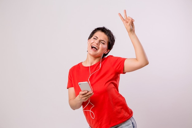 young girl listening to music on the phone and dancing