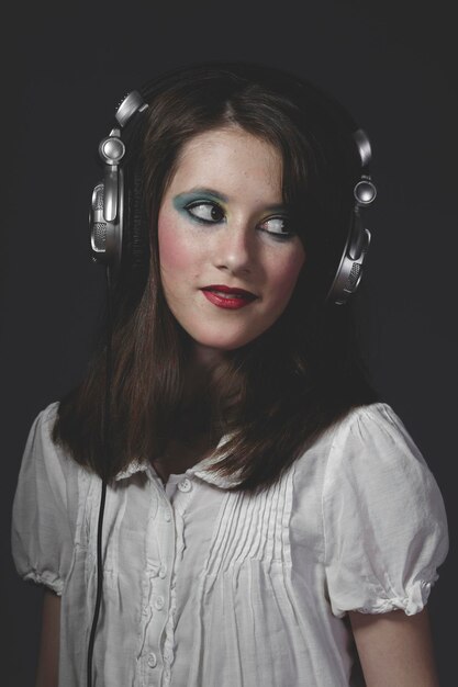 young girl listening music with huge headphones