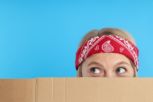 A young girl looks from behind the box