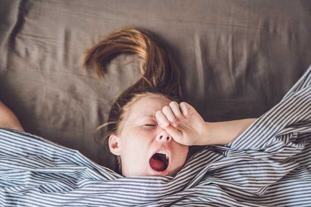 Young girl lying in bed under a blanket