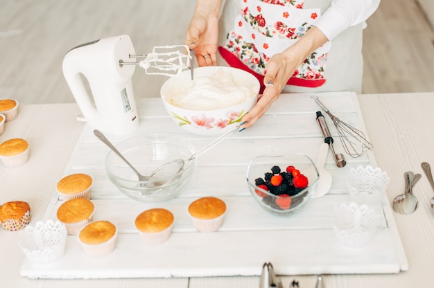 Young girl making cream for cupcakes.