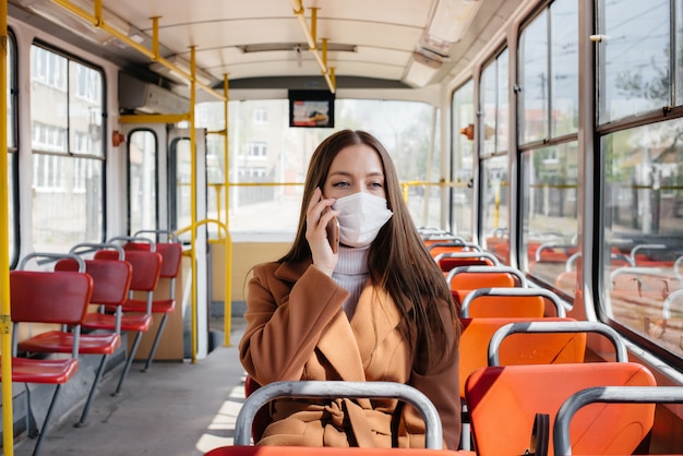 A young girl in a mask uses public transport alone, during a pandemic. Protection and prevention covid 19.