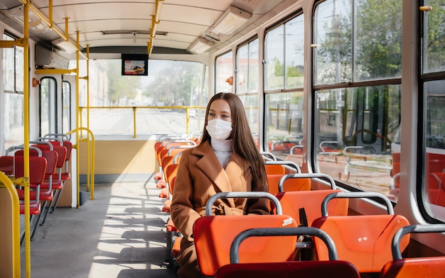 A young girl in a mask uses public transport alone, during a pandemic. Protection and prevention covid 19.