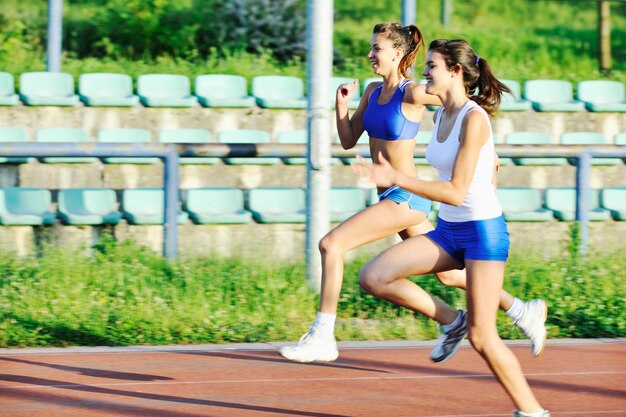 若い女の子の朝の実行と運動競馬場での競争