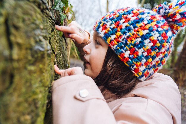 Foto una ragazzina in un'escursione in natura in inverno alla ricerca di insetti