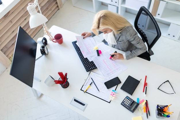 Young girl in the office working with a marker and documents