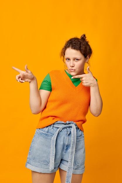 Young girl in orange sweater youth clothing posing isolated background