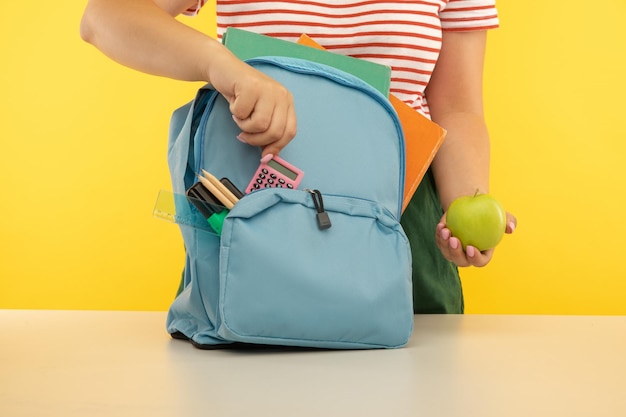 Young girl packing blue backpack back to school concept