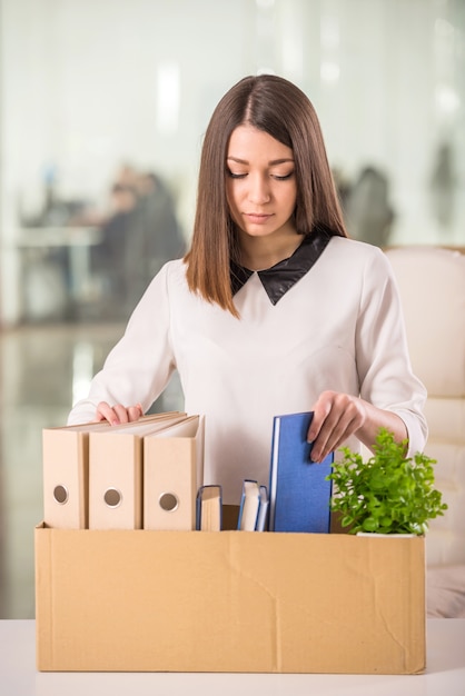 Young girl packing boxes in office.