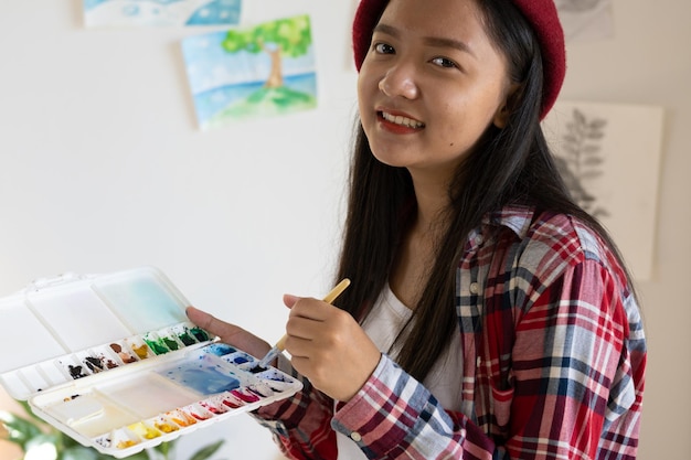 Young girl painting on paper at home wood frameHobby and art study at home