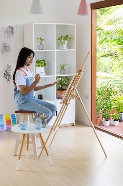 Ragazza che dipinge su carta a casa cornice in legnohobby e studio d'arte a casa