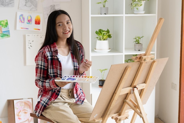 Ragazza che dipinge su carta a casa cornice in legnohobby e studio d'arte a casa