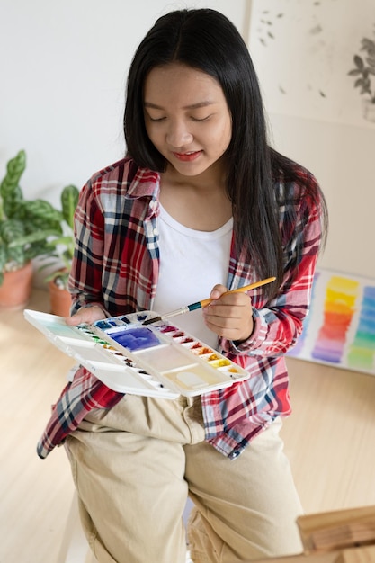 Ragazza che dipinge su carta a casa cornice in legnohobby e studio d'arte a casa