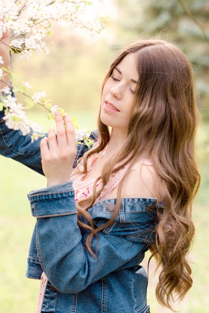 Young girl in a park with blooming flowers