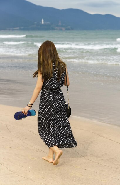 Young girl passing by on the china beach in danang, in vietnam. no face