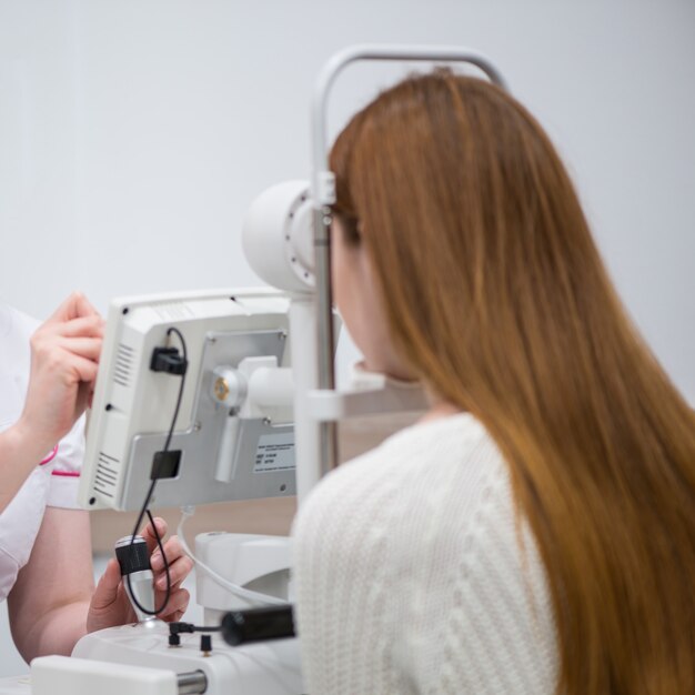 Foto paziente della ragazza alla reception presso il medico oculista attrezzature oftalmologiche diagnostiche